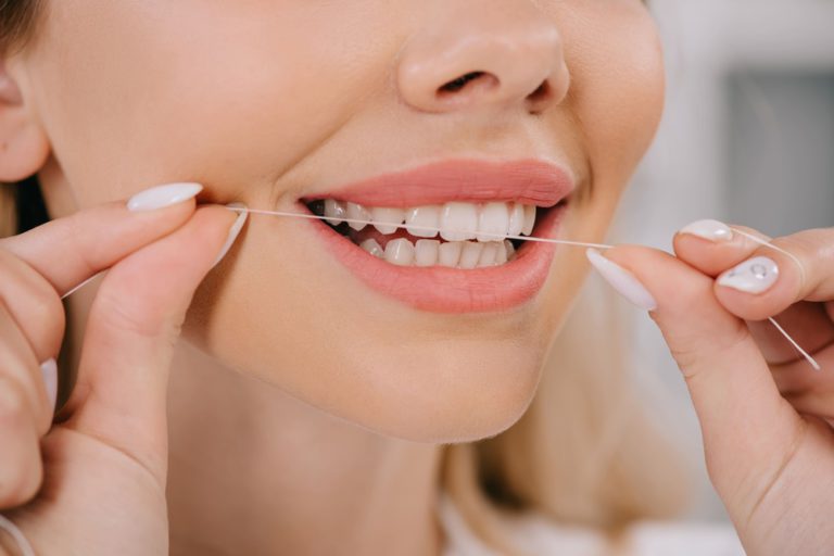 partial view of woman flossing teeth with dental f 2021 09 03 16 53 35 utc