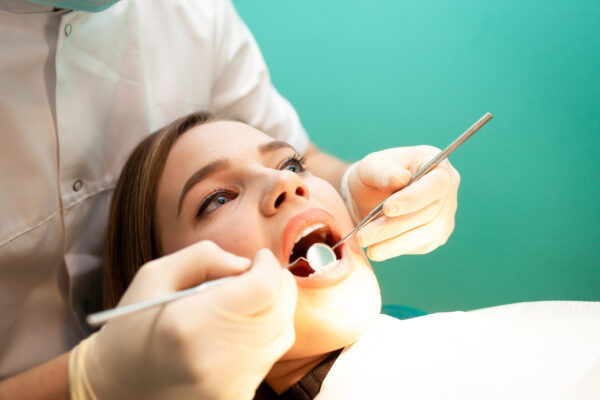 Dentist treats the woman teeth close-up. Young woman visited a dentist.